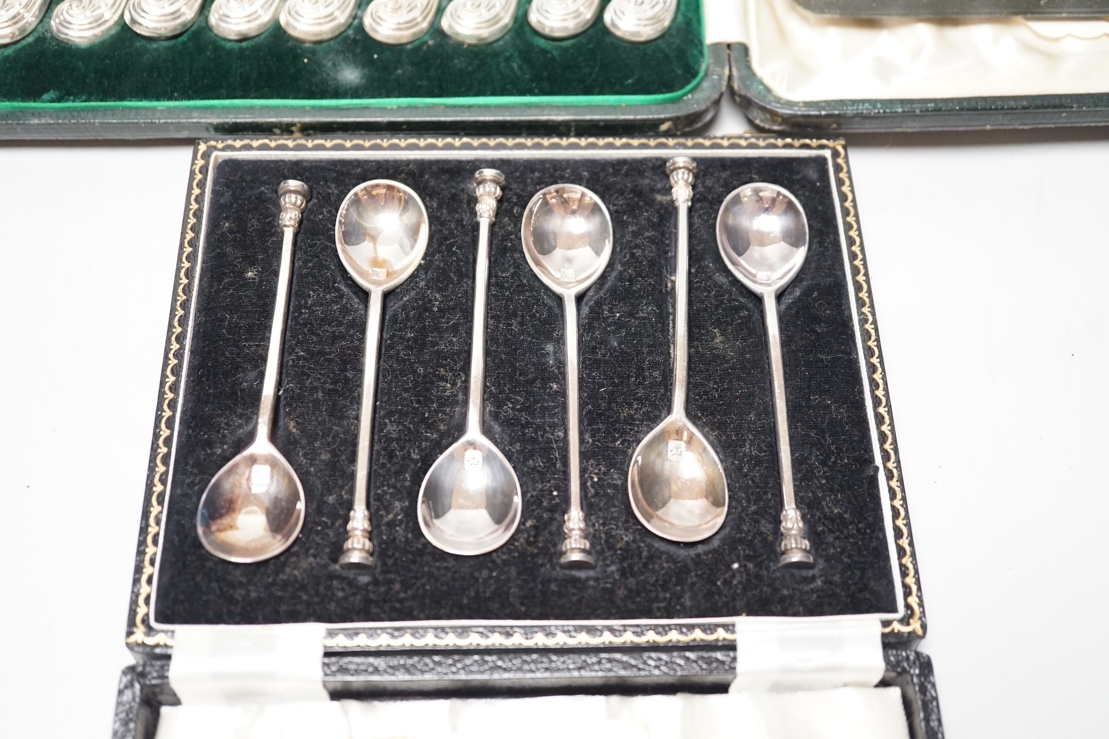 A cased set of twelve silver handled dessert knives, six seal-top teaspoons, five (ex 6) teaspoons and tongs.